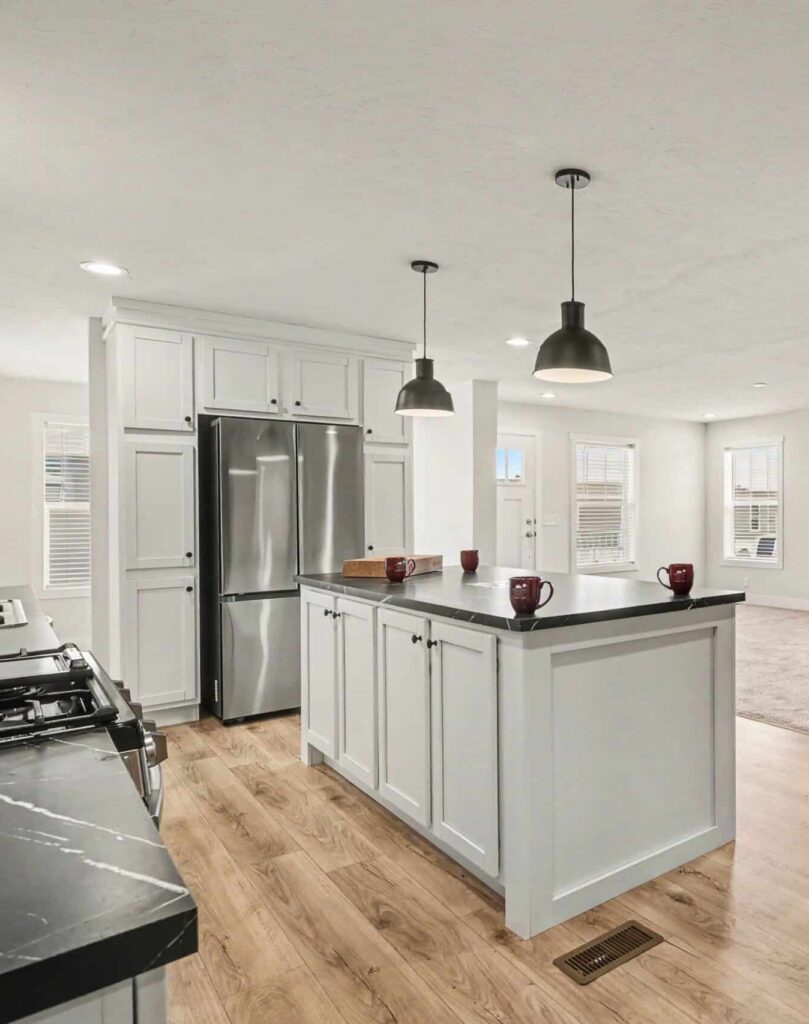 White kitchen with island and stainless appliances in a new manufactured home in Allendale, MI