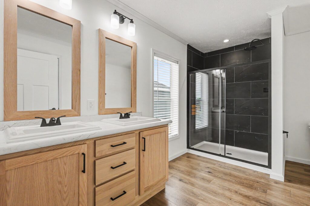 Bathroom with oak double vanity and tile shower in a new manufactured home in Allendale, MI