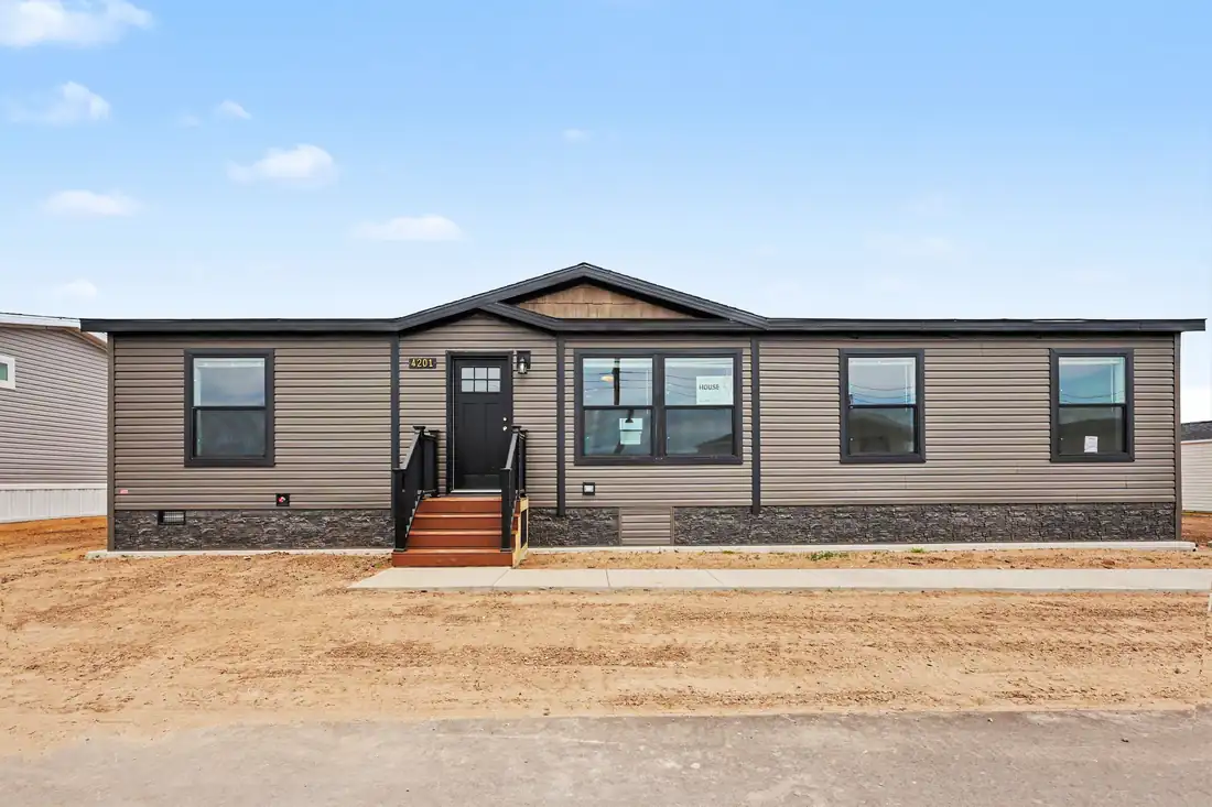 Front exterior of a new brown manufactured home with stone skirting in Allendale, MI