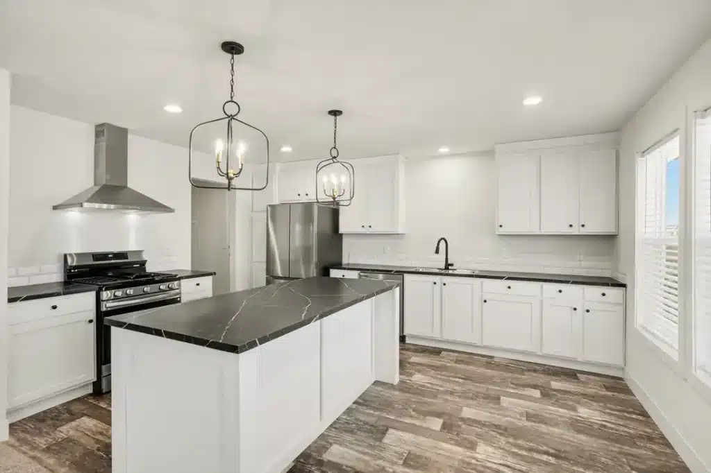 White kitchen with island and range hood in a new manufactured home in Allendale, MI