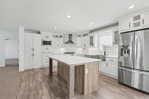 Kitchen with island and stainless refrigerator in a new manufactured home at 11856 Danton Circle in Allendale, MI