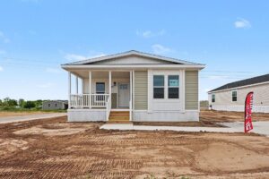 Front porch of a new manufactured home with tan siding and white railings at 4140 Shalimar Dr in Allendale, MI