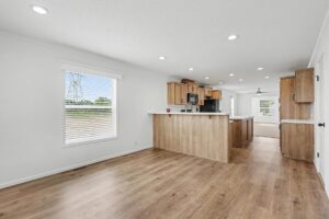 Kitchen with light oak cabinets, island and black appliances in a new manufactured home at 4140 Shalimar Dr in Allendale, MI