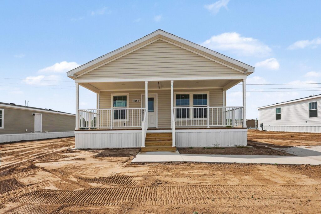 Covered front porch of a new manufactured home with cream siding at 4152 Shalimar Dr in Allendale, MI
