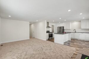 Open living room and kitchen with island in a new manufactured home at 4152 Shalimar Dr in Allendale, MI