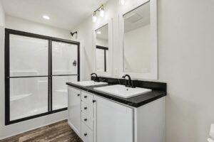 Bathroom with double-sink vanity and glass shower doors in a new manufactured home at 4152 Shalimar Dr in Allendale, MI