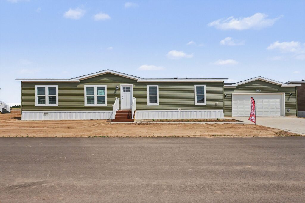 Front exterior of a new green manufactured home with attached garage at 4159 Shalimar Dr in Allendale, MI