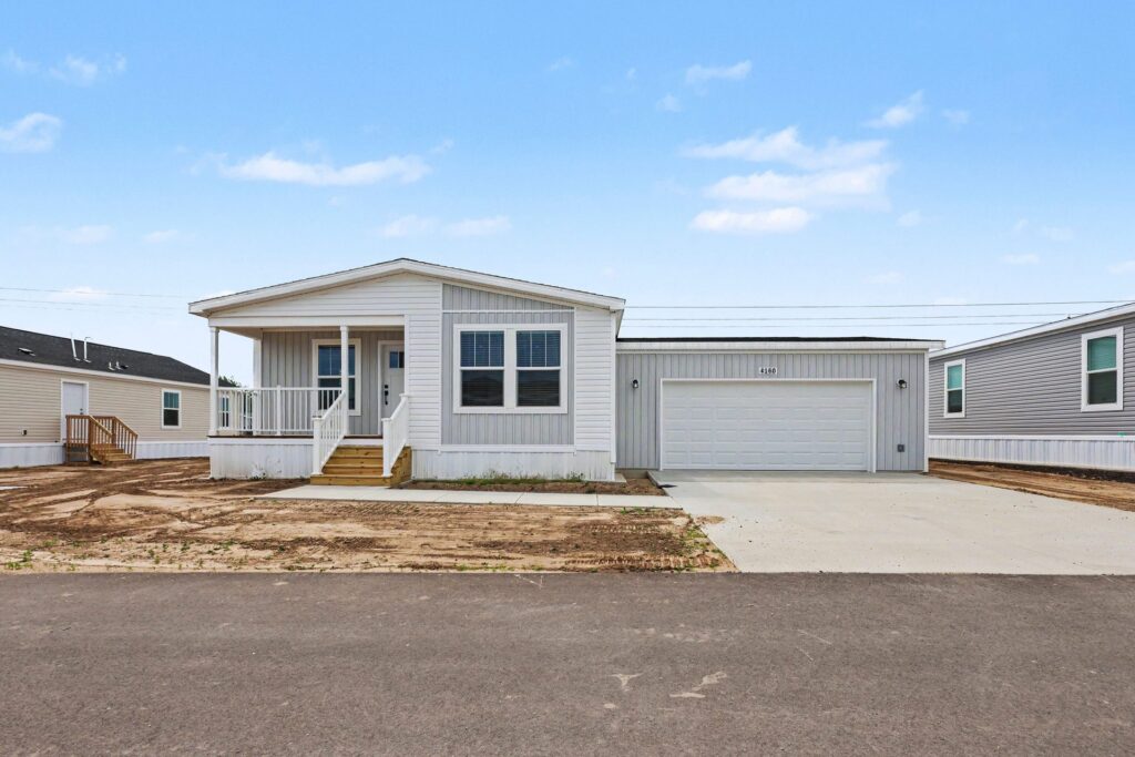 Front exterior of a new white manufactured home with attached garage at 4160 Shalimar Dr in Allendale, MI