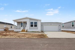 Front exterior of a new white manufactured home with attached garage at 4160 Shalimar Dr in Allendale, MI