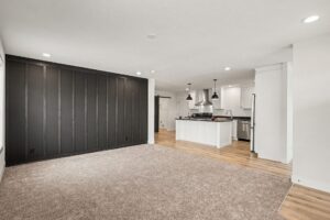 Living room with dark accent wall opening to the kitchen in a new manufactured home at 4160 Shalimar Dr in Allendale, MI