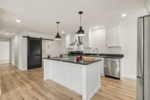 Kitchen with barn door pantry and stainless refrigerator in a new manufactured home at 4160 Shalimar Dr in Allendale, MI