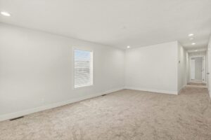 Long carpeted living room with hallway in a new manufactured home at 4180 Shalimar Dr in Allendale, MI