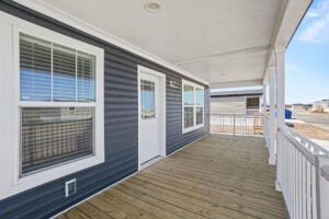 Covered front porch with navy siding on a new manufactured home at 4180 Shalimar Dr in Allendale, MI