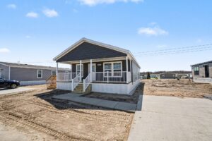 Front exterior of a new navy manufactured home with covered porch at 4180 Shalimar Dr in Allendale, MI