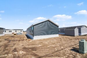 Side exterior of a new navy manufactured home on its lot at 4180 Shalimar Dr in Allendale, MI