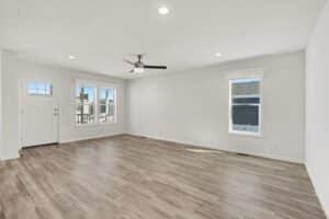 Living room with wood-look flooring and ceiling fan in a new manufactured home at 4188 Shalimar Dr in Allendale, MI