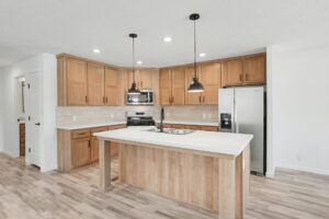 Kitchen with oak cabinets, island and stainless appliances in a new manufactured home at 4188 Shalimar Dr in Allendale, MI