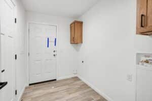 Laundry room with oak cabinet and exterior door in a new manufactured home at 4188 Shalimar Dr in Allendale, MI