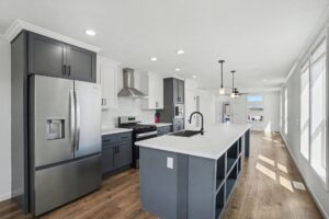 Kitchen with stainless refrigerator and gray island in a new manufactured home at 4198 Shalimar Dr in Allendale, MI