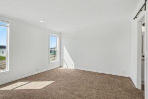 Carpeted primary bedroom with two windows in a new manufactured home at 4198 Shalimar Dr in Allendale, MI