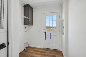 Laundry room with gray cabinet and exterior door in a new manufactured home at 4198 Shalimar Dr in Allendale, MI