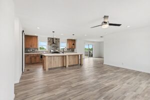 Living room with ceiling fan opening to the kitchen in a new manufactured home at 4201 Shalimar Dr in Allendale, MI