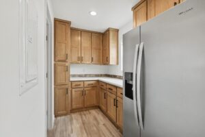 Kitchen corner with oak cabinets and stainless refrigerator in a new manufactured home at 4201 Shalimar Dr in Allendale, MI