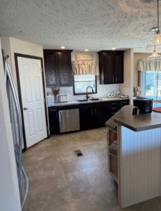 Kitchen with dark cabinets and window in a pre-owned manufactured home at 4393 Twilight Way in Allendale, MI