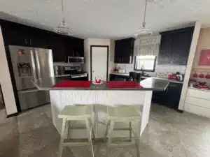 Kitchen island with bar stools and stainless appliances in a pre-owned manufactured home at 4393 Twilight Way in Allendale, MI