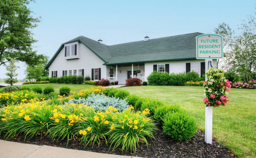 Boulder Ridge clubhouse with landscaped flower beds at the manufactured home community near Grand Rapids, MI
