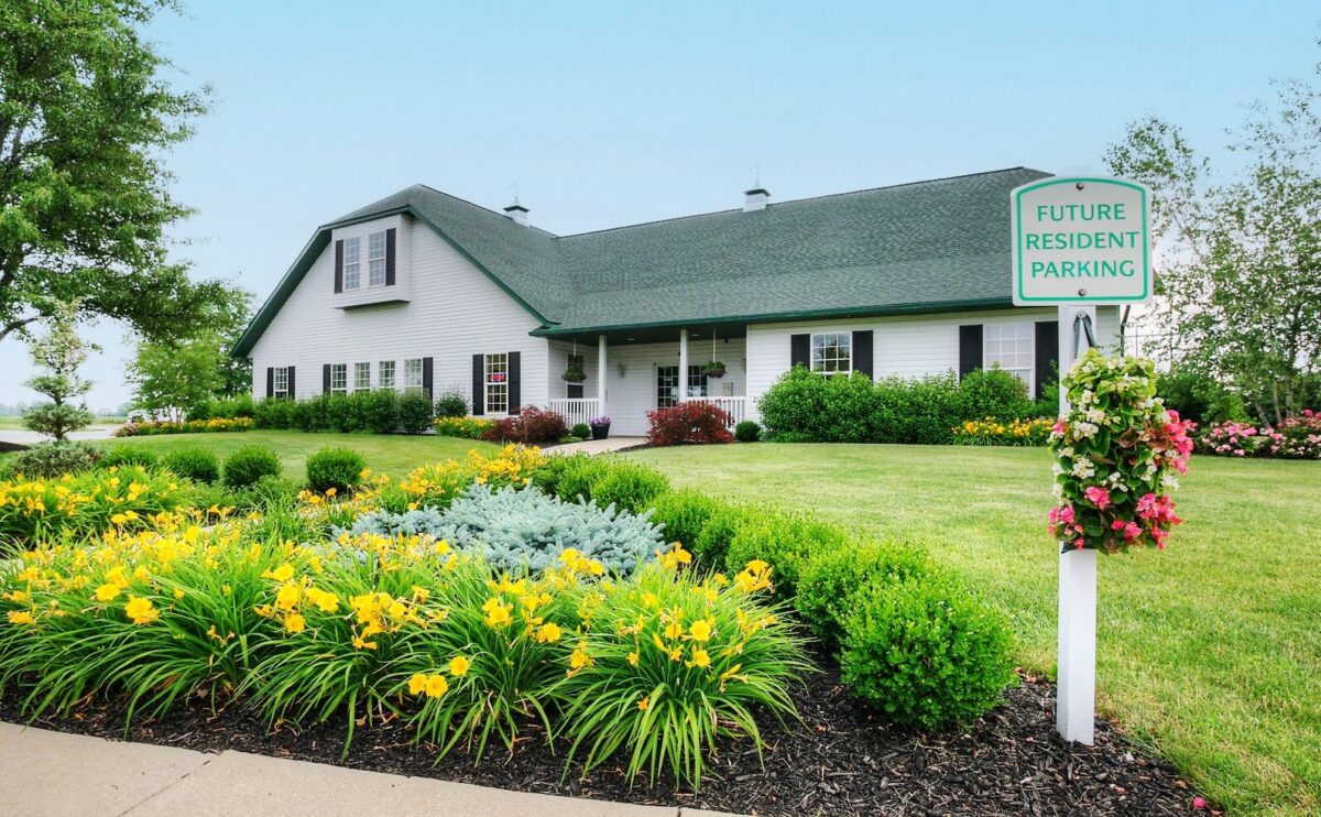 Boulder Ridge clubhouse with landscaped flower beds at the manufactured home community in Allendale, MI