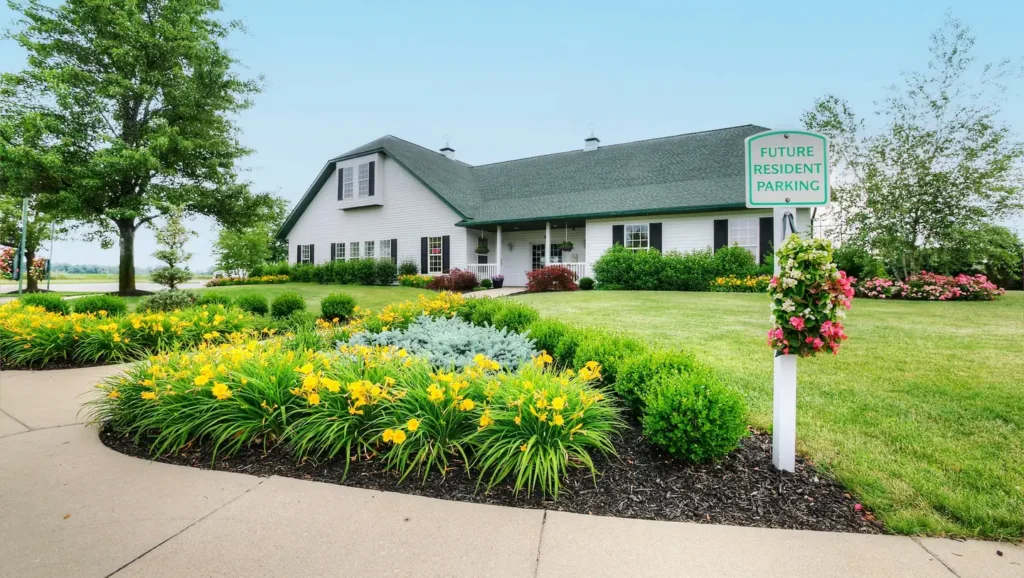 Boulder Ridge clubhouse with landscaped flower beds at the manufactured home community in Allendale, MI