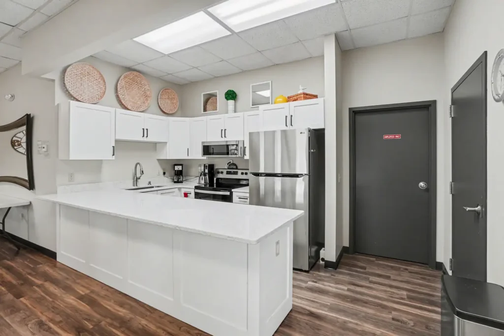 Clubhouse kitchen with white cabinets and stainless appliances at the manufactured home community in Allendale, MI