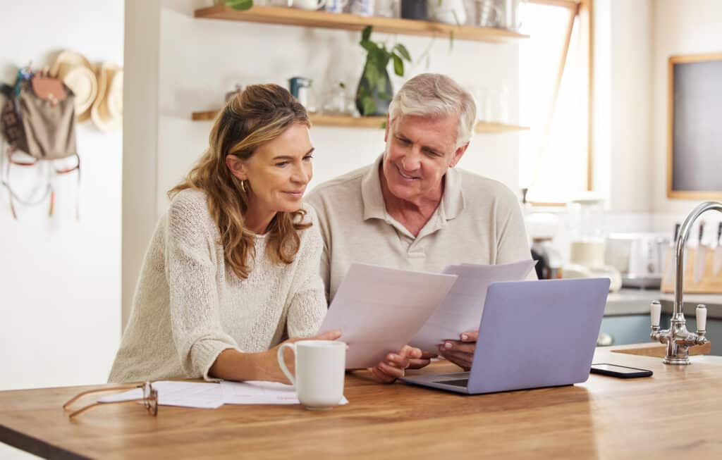 Couple reviewing manufactured home financing paperwork at a laptop in Allendale, MI