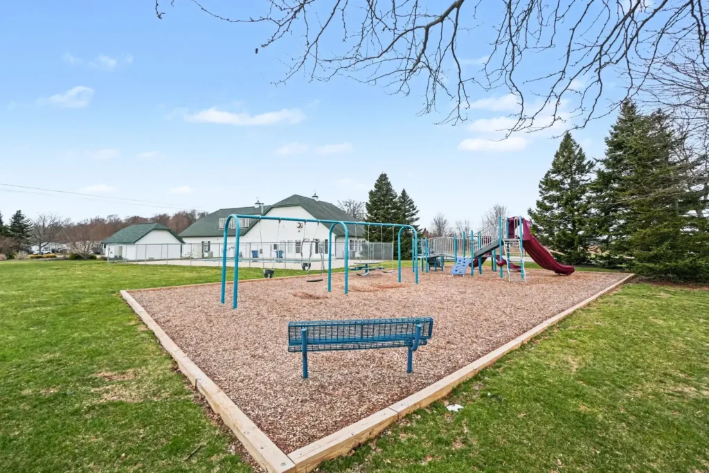 Community playground with swings and slide at the manufactured home community in Allendale, MI
