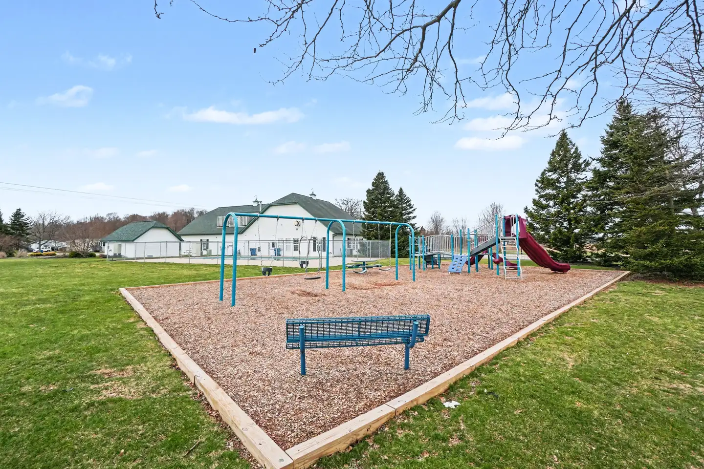 Community playground with swings and slide at the manufactured home community in Allendale, MI