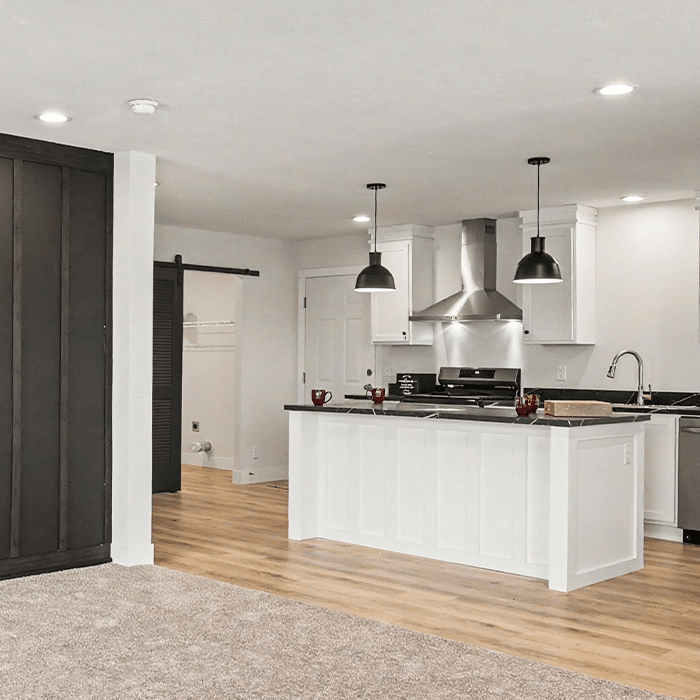 White kitchen with island and range hood in a quality manufactured home in Allendale, MI