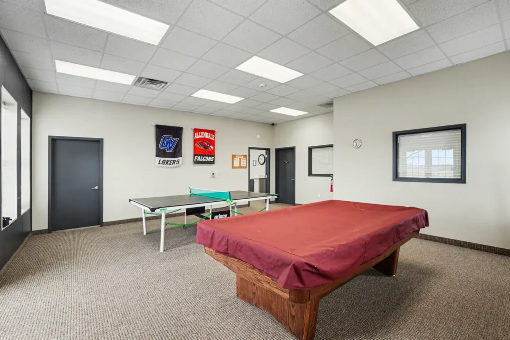 Recreation room with pool table and ping-pong table in the clubhouse in Allendale, MI
