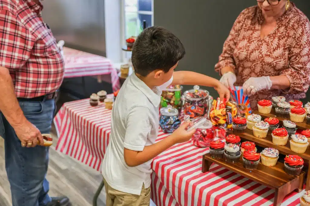 Young resident choosing a cupcake at the Festive Celebration dessert table