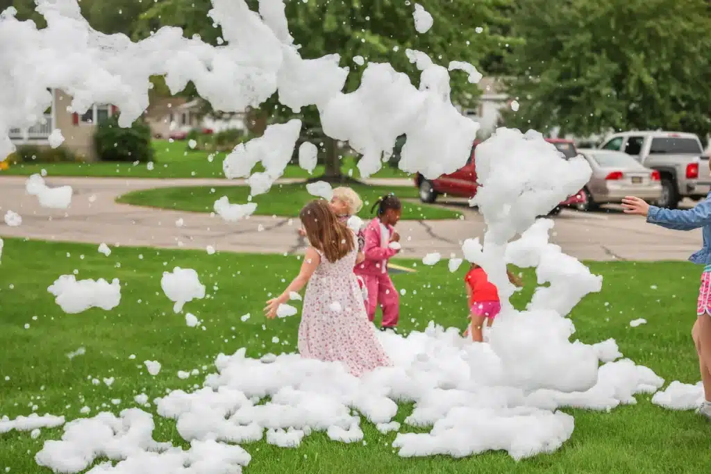 Girl running through foam at the Festive Celebration